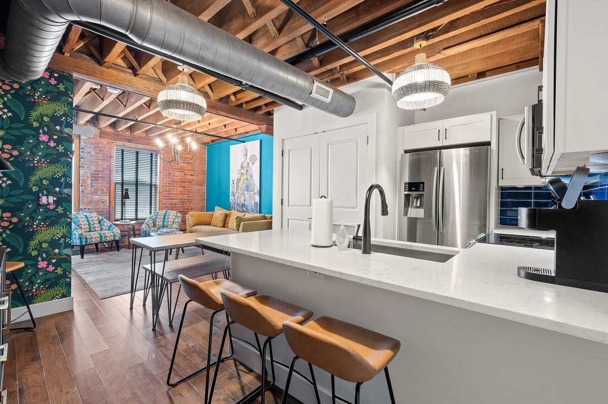 A loft kitchen at the 1865, brick and beams overhead