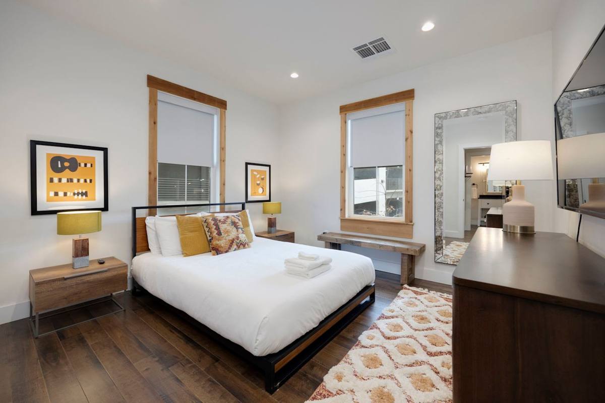 Warm and inviting bedroom with cozy hardwood floors and a beautifully made bed, perfect for a restful night's sleep