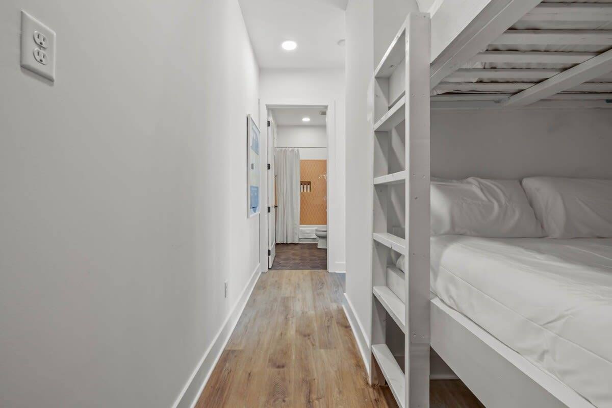 Elevate your spaces into havens of comfort with this pristine white bunk bed nestled in a hallway. Effortlessly merging functionality and elegance, it promises to create a serene sanctuary for little ones or a captivating guest room!