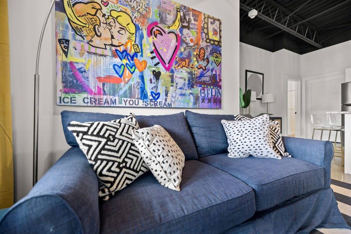 Step into tranquility with our stylish living space, complete with a soothing blue couch and a captivating painting