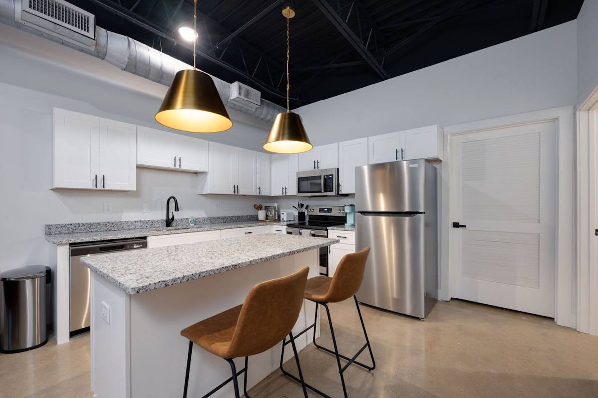 Discover a sleek and modern kitchen adorned with clean lines, white cabinets, and stainless steel appliances, creating an elegant and functional culinary space.