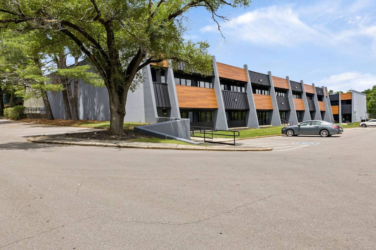 Nestled amidst the hustle and bustle of daily work life, the rental building stands as a testament to efficiency and organization, complemented by the presence of parked cars as hardworking employees take on the challenges of the day.
