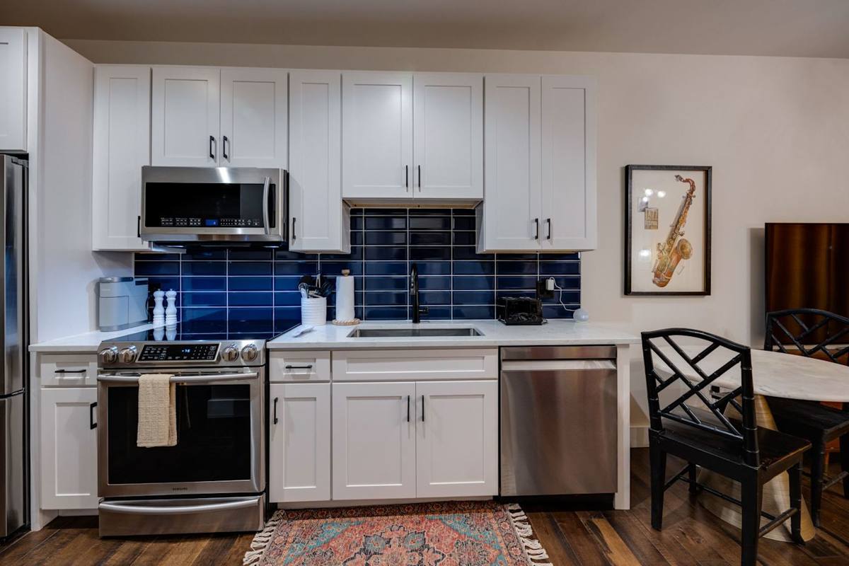 Step into a serene and modern kitchen space adorned with soothing blue cabinets and warm hardwood floors, creating a harmonious atmosphere that blends style and comfort seamlessly.