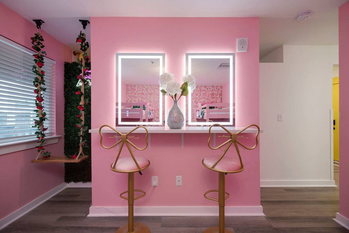 Vanity Lounge: Chic pink décor with playful seating and vibrant floral accents for unforgettable selfies!