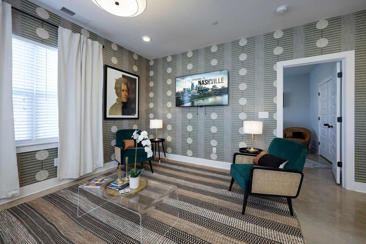 The living room at The Presidential in The Nations, patterned wallpaper and a velvet chair